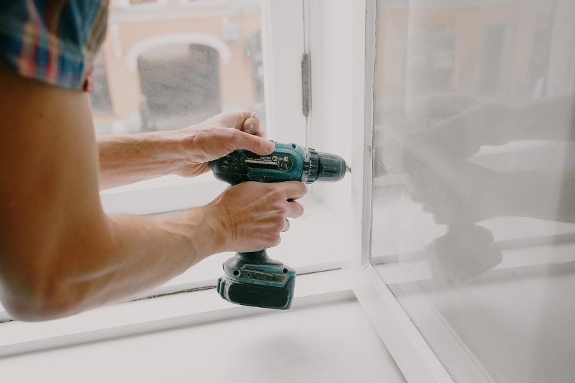 Man drilling window frame